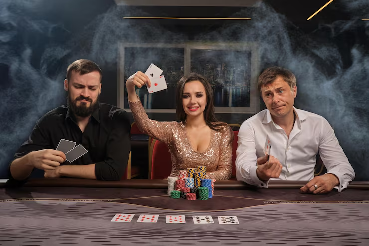 Black-tie guests at a poker table under chandelier light